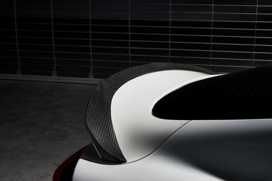 How is the carbon fiber rear spoiler for 2024 Toyota Supra attached to the trunk?